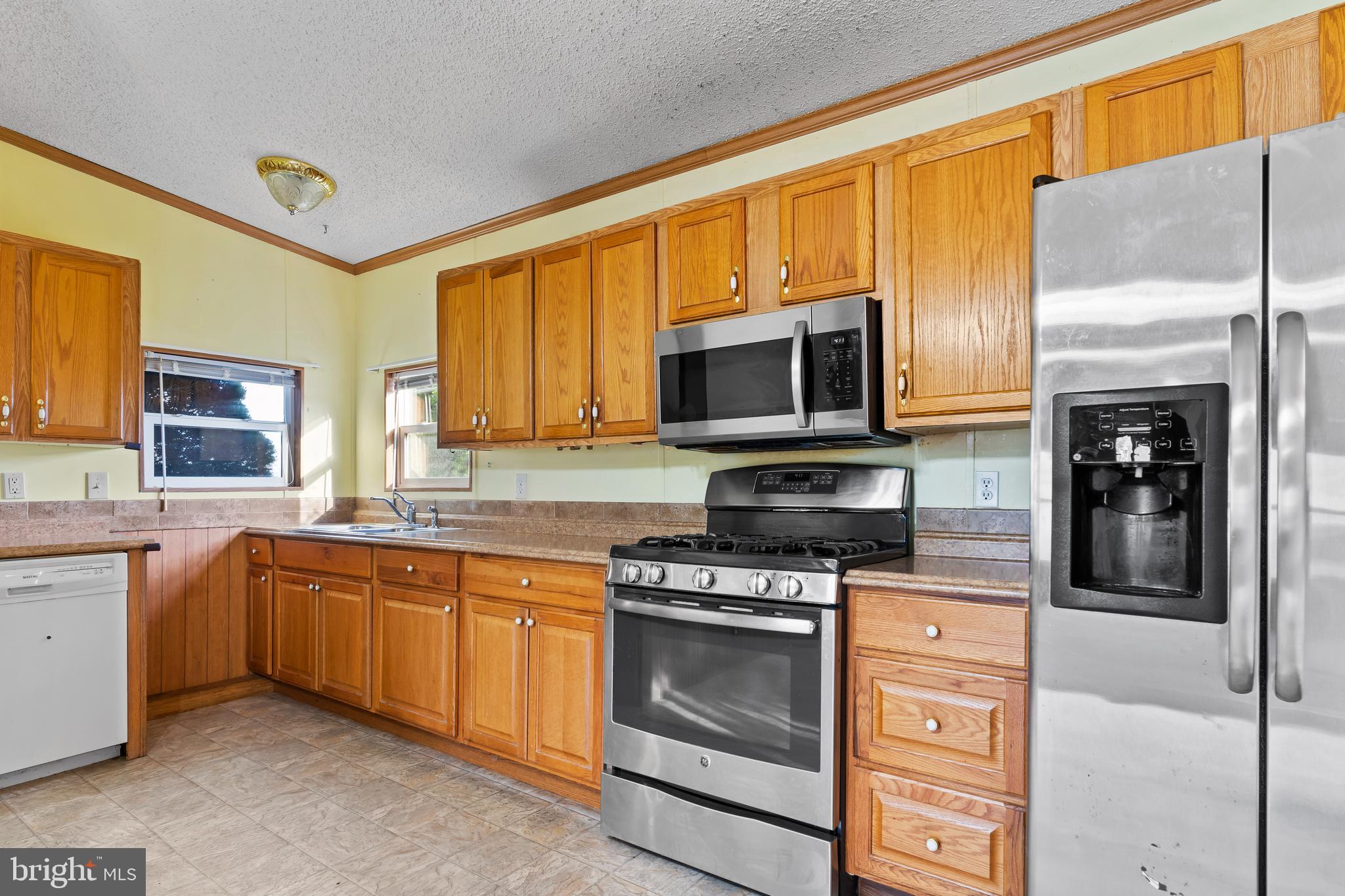 21 Hidden Noll Road Carlisle, PA 17013 - Photo 7 of 25 a kitchen with stainless steel appliances granite countertop a stove top oven a sink dishwasher a refrigerator and a microwave oven