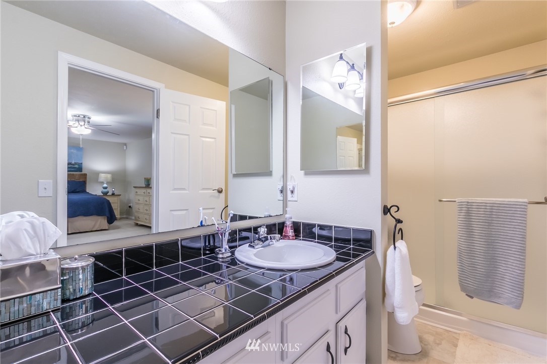 15612 Southeast 178th Street Renton, WA 98058 - Photo 31 of 40 a en suite bathroom with a granite countertop sink and a mirror