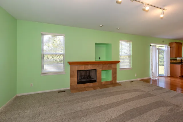 an empty room with fireplace and a window