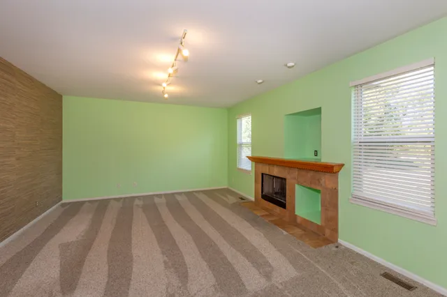 a view of empty room with a fireplace and a window
