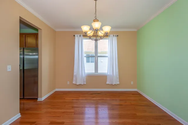 a view of a room with window wooden floor and chandelier