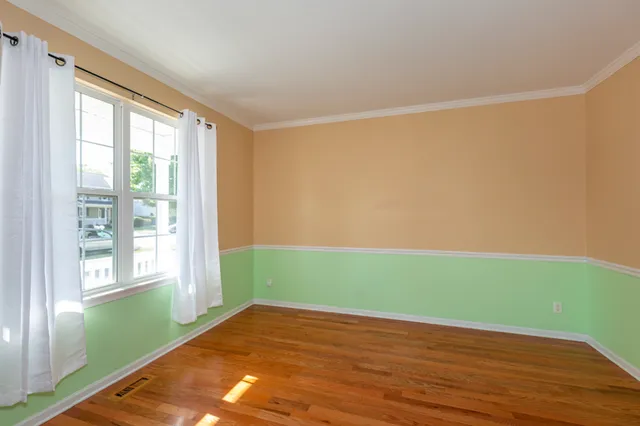a view of a room with wooden floor and a window
