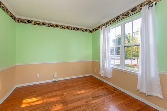 a view of a big room with wooden floor and windows