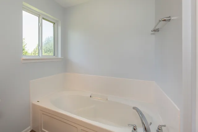 a white bath tub sitting next to a window