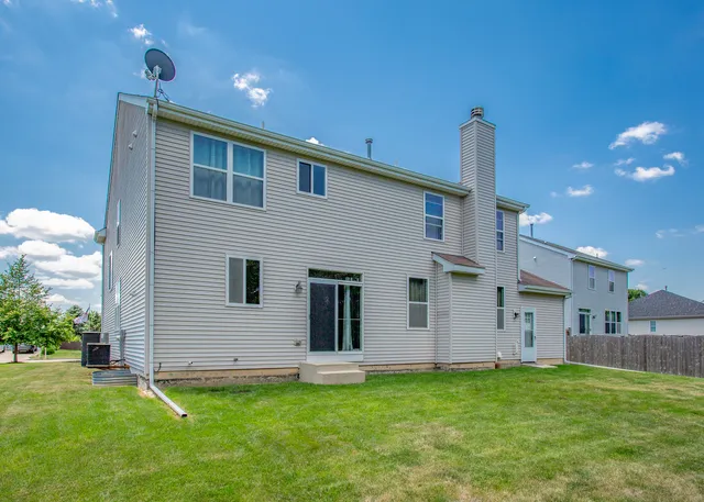 a backyard of a house with table and chairs