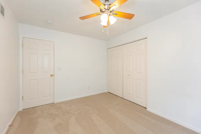 a white toilet sitting next to a white wall