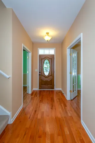 a view of an empty room with window and wooden floor