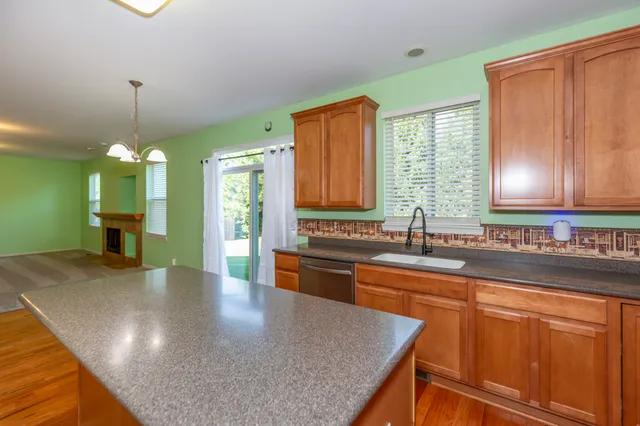 a kitchen with stainless steel appliances granite countertop a sink a stove counter space and cabinets