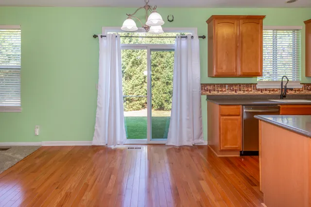 a view of a kitchen with wooden floor and a window