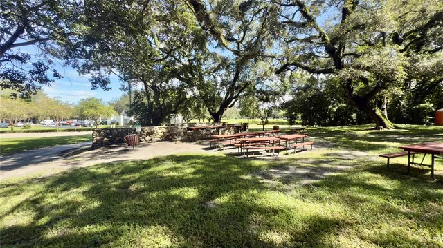 a view of a park with a table chairs and a lake view