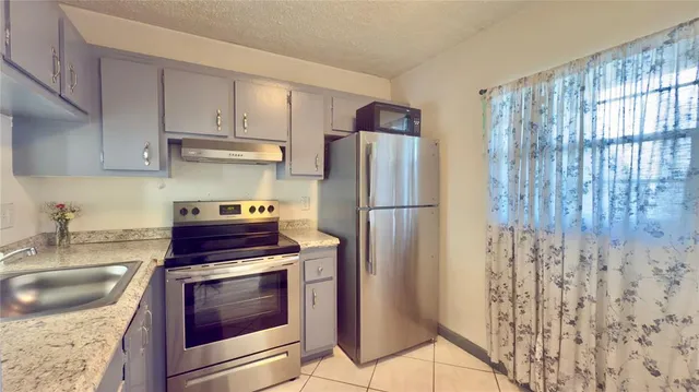 a kitchen with a refrigerator and a stove