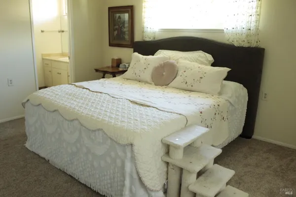 a bed sitting in a bedroom next to a window