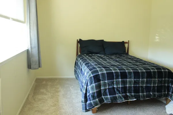 a bed sitting in a bedroom next to a window
