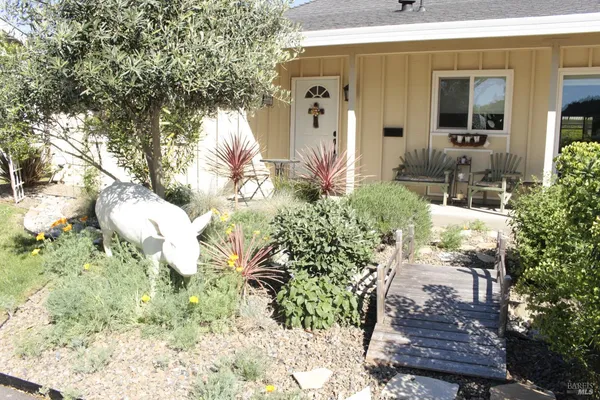 a front view of a house with a yard and plants