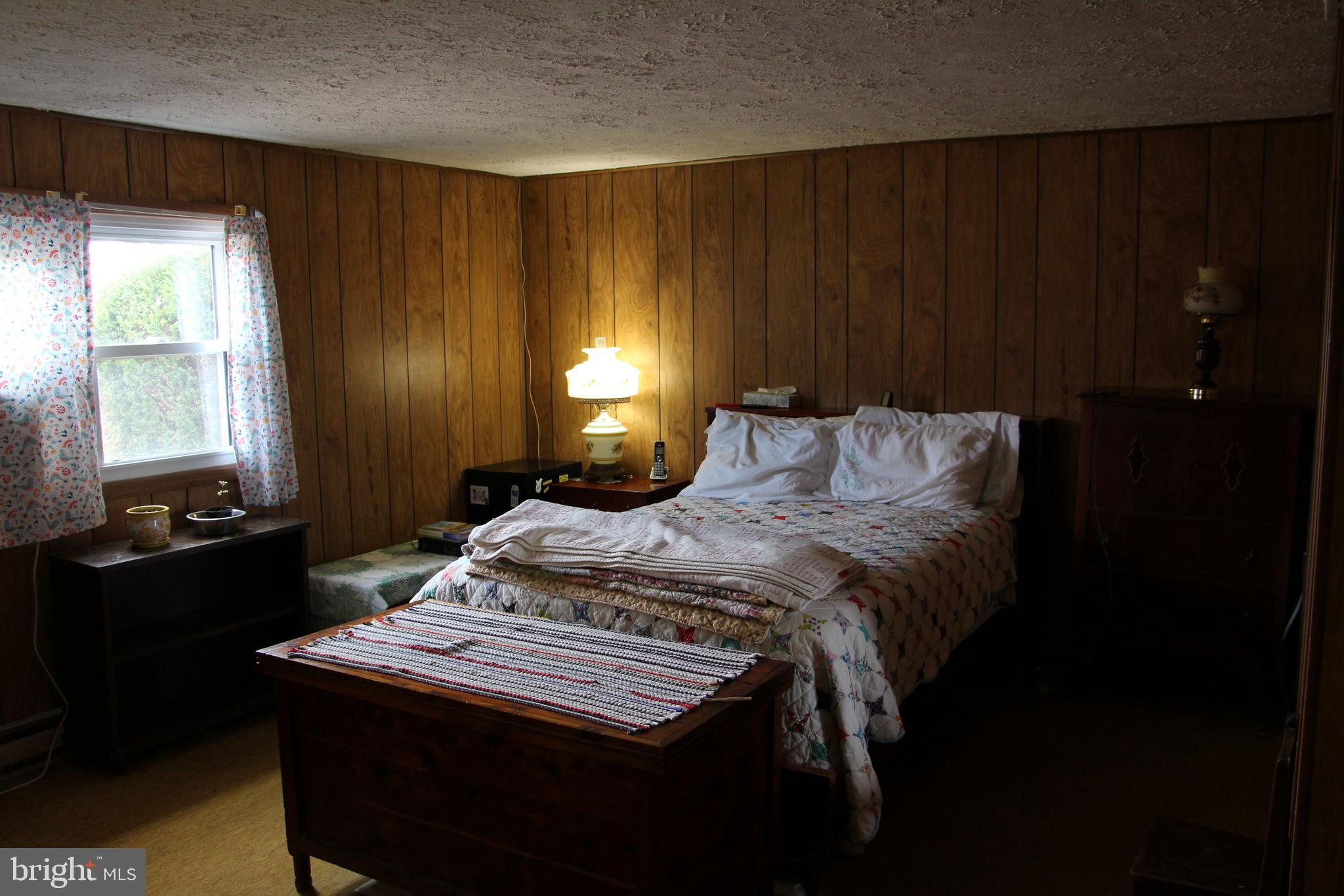 775 Corners Road Cabins, WV 26855 - Photo 17 of 20 a bedroom with a bed and a lamp on table