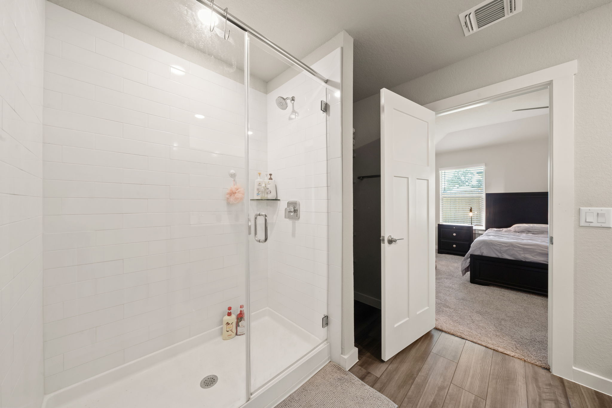 1117 Tipton Street Georgetown, TX 78633 - Photo 23 of 40 Enclosed shower with clear glass door, white subway tile surround, chrome fixtures, and a recessed wall shelf