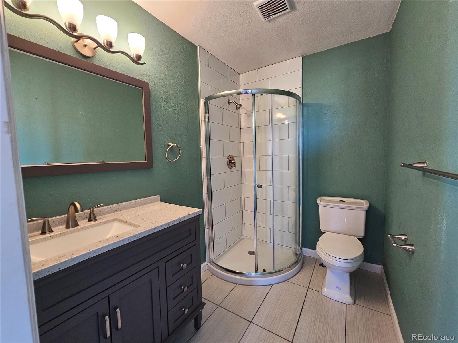 16985 Sage Crest Road Peyton, CO 80831 - Photo 18 of 25 a bathroom with a sink a toilet a mirror and shower