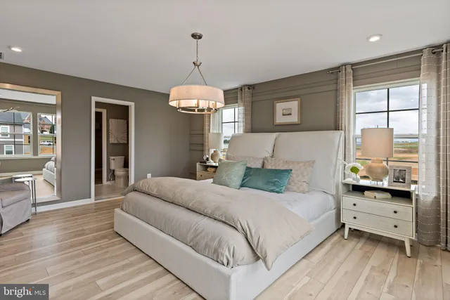 a bedroom with a large bed and a chandelier