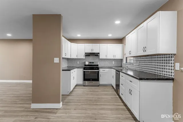 a kitchen with granite countertop stainless steel appliances and white cabinets