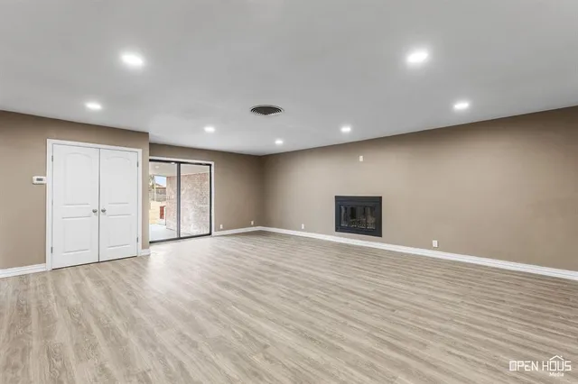 a view of an empty room with wooden floor and entryway