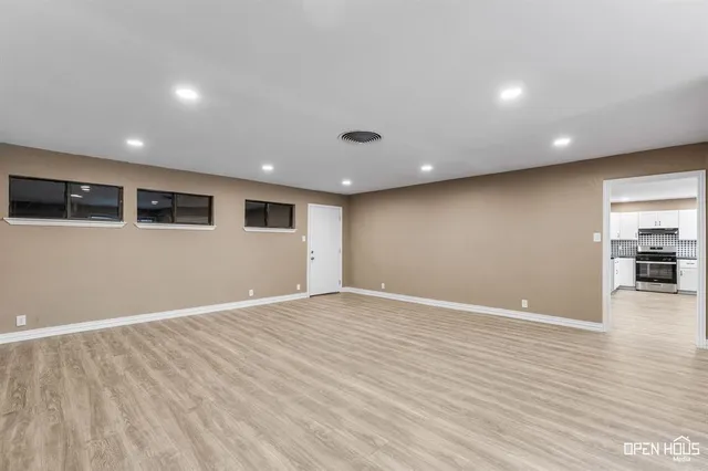 a view of an empty room with wooden floor