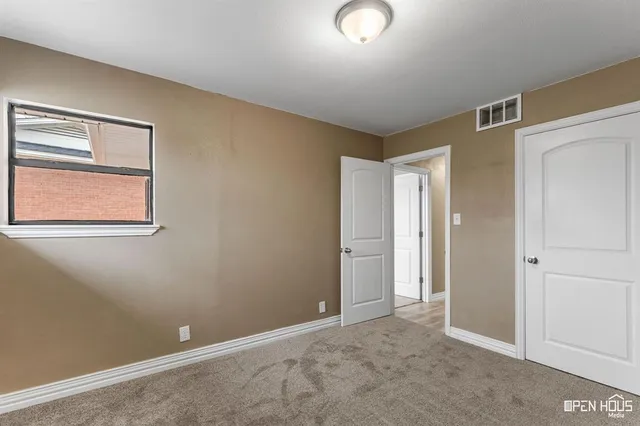 an empty room with windows and closet