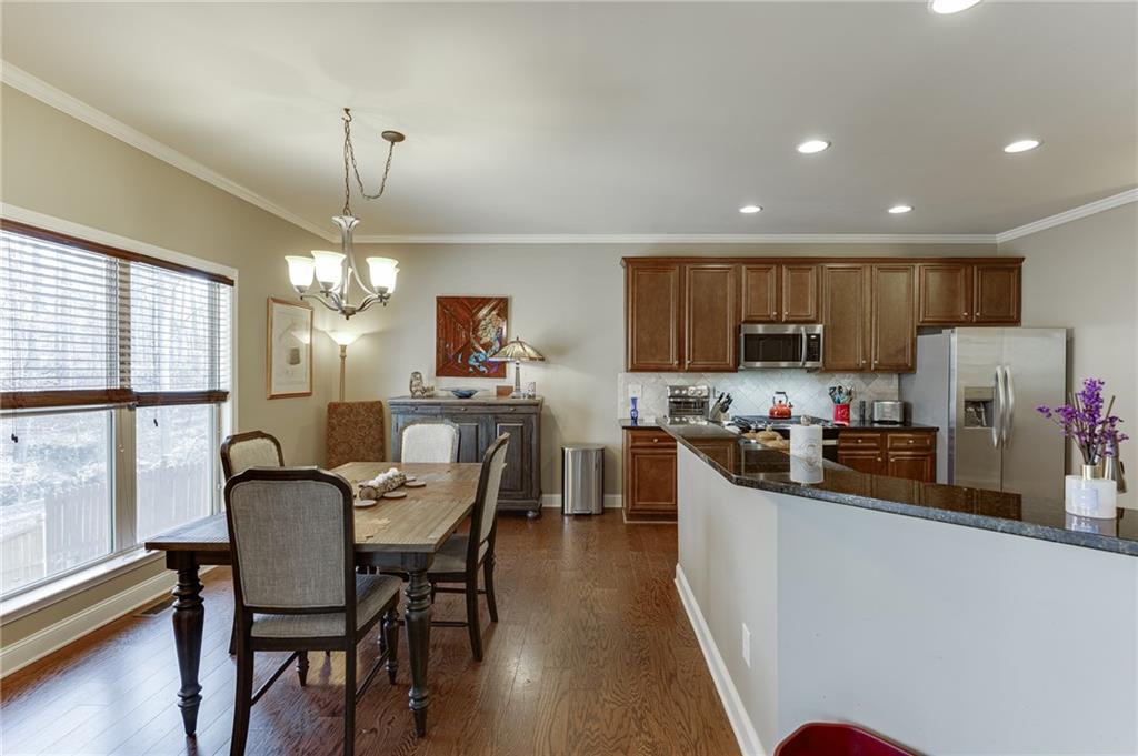 2201 Spring Sound Lane Buford, GA 30519 - Photo 15 of 66 a kitchen with a dining table chairs refrigerator and cabinets