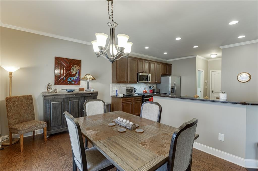 2201 Spring Sound Lane Buford, GA 30519 - Photo 16 of 66 a view of a dining room with furniture wooden floor and chandelier