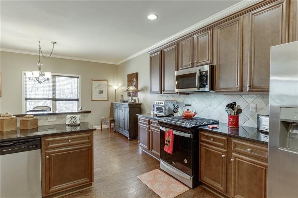 2201 Spring Sound Lane Buford, GA 30519 - Photo 22 of 66 a kitchen with granite countertop a sink cabinets and stainless steel appliances