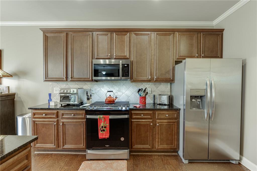2201 Spring Sound Lane Buford, GA 30519 - Photo 23 of 66 a kitchen with stainless steel appliances granite countertop a refrigerator stove and microwave