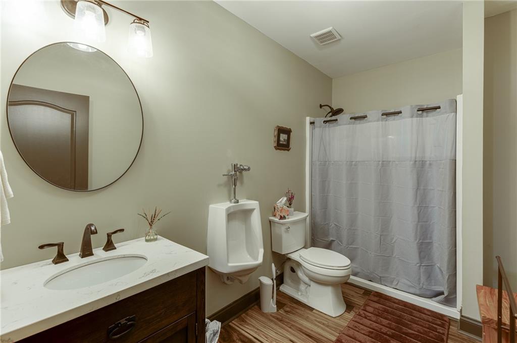 2201 Spring Sound Lane Buford, GA 30519 - Photo 45 of 66 a bathroom with a granite countertop toilet sink a mirror and vanity