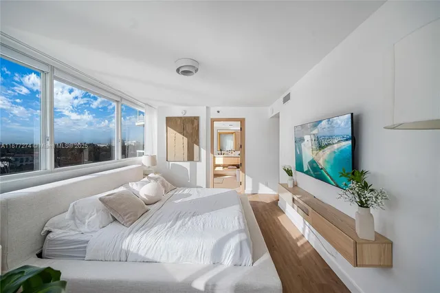 a bedroom with a large bed and a flat screen tv