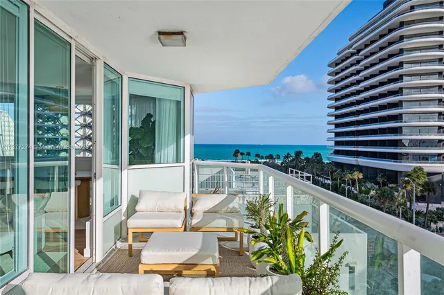 a view of a balcony with chairs and a potted plant