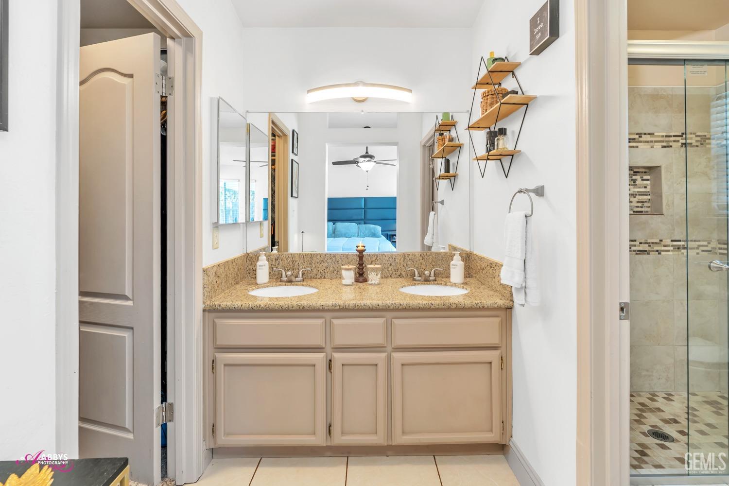 Undisclosed Address Bakersfield, CA 93312 - Photo 13 of 30 a bathroom with a granite countertop sink a mirror and a shower