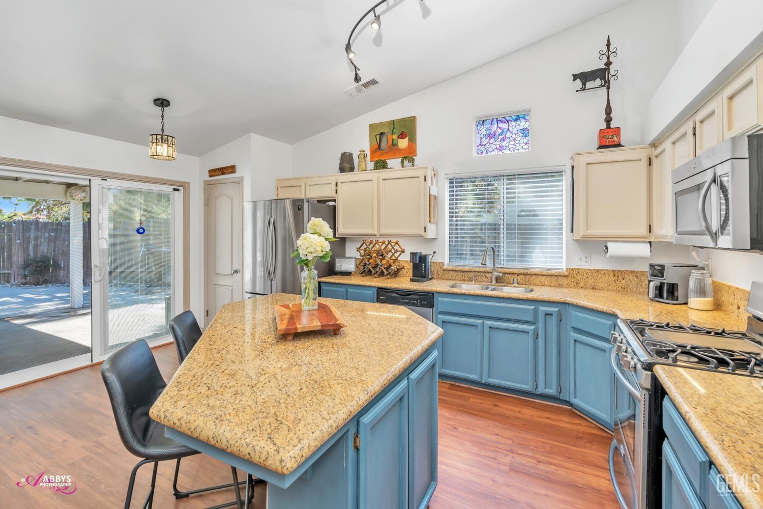 Undisclosed Address Bakersfield, CA 93312 - Photo 6 of 30 a kitchen with granite countertop kitchen island stainless steel appliances a sink table and chairs