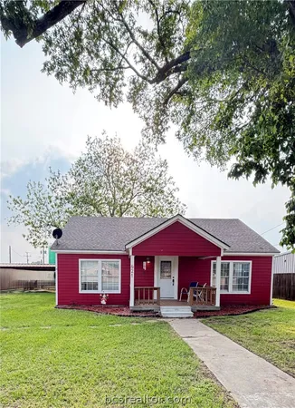 a view of a house with a yard balcony and tree