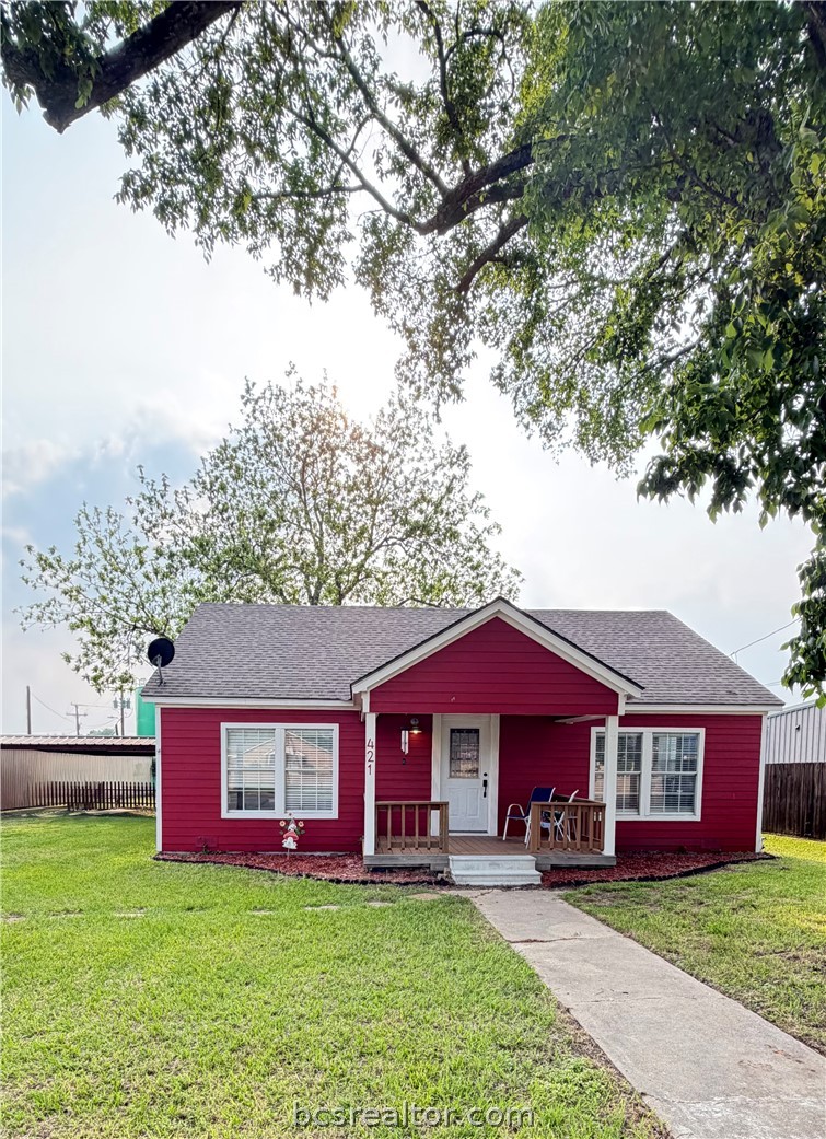 a view of a house with a yard balcony and tree