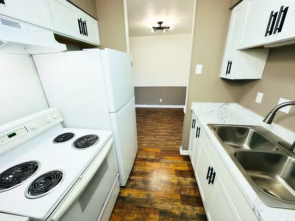 a kitchen with a white stove top oven and cabinets