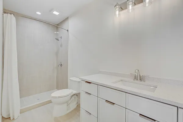 a bathroom with a sink a toilet and shower