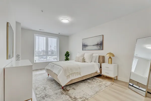 a spacious bedroom with a bed a couch and a window