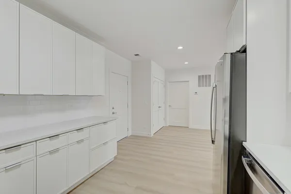 a view of a kitchen with white cabinets