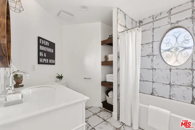 a bathroom with a sink a toilet and a shower