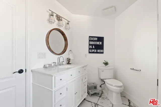 a bathroom with a toilet a sink and a mirror