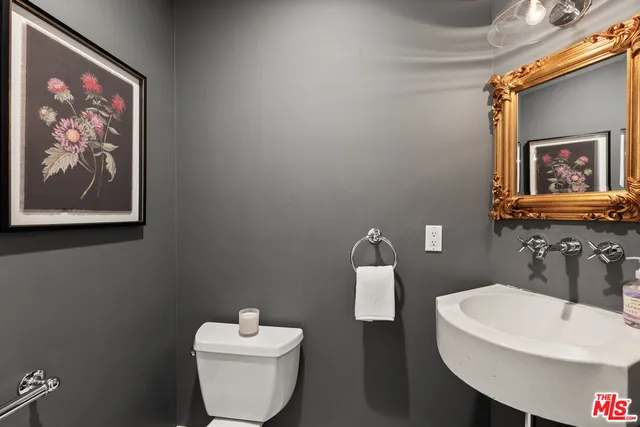 a bathroom with a toilet a sink and mirror