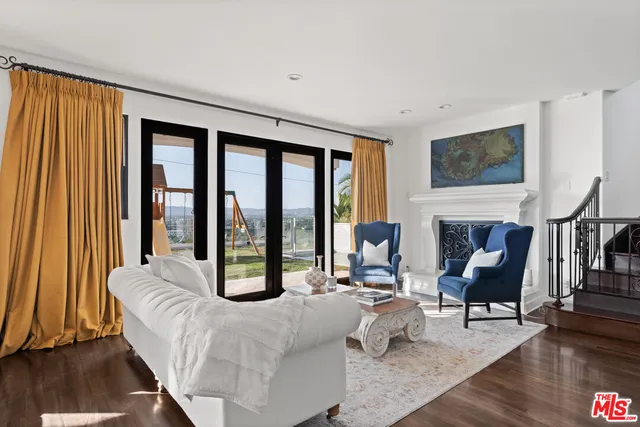 a living room with furniture large window and a fireplace