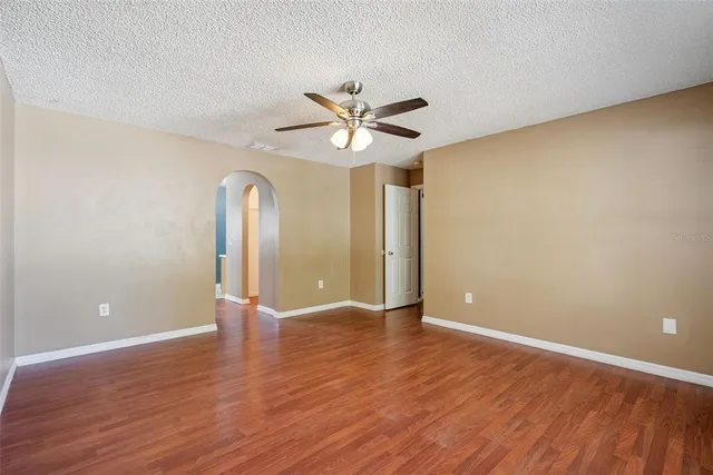 a view of an empty room with window and wooden floor