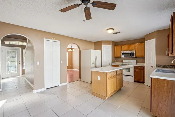 a kitchen with a stove top oven and refrigerator