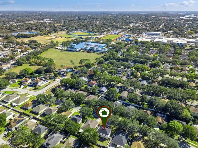 an aerial view of residential houses with outdoor space and trees