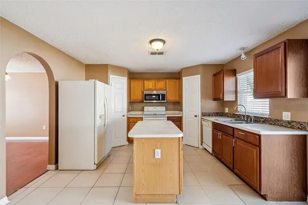 a kitchen with stainless steel appliances granite countertop a refrigerator and a stove top oven