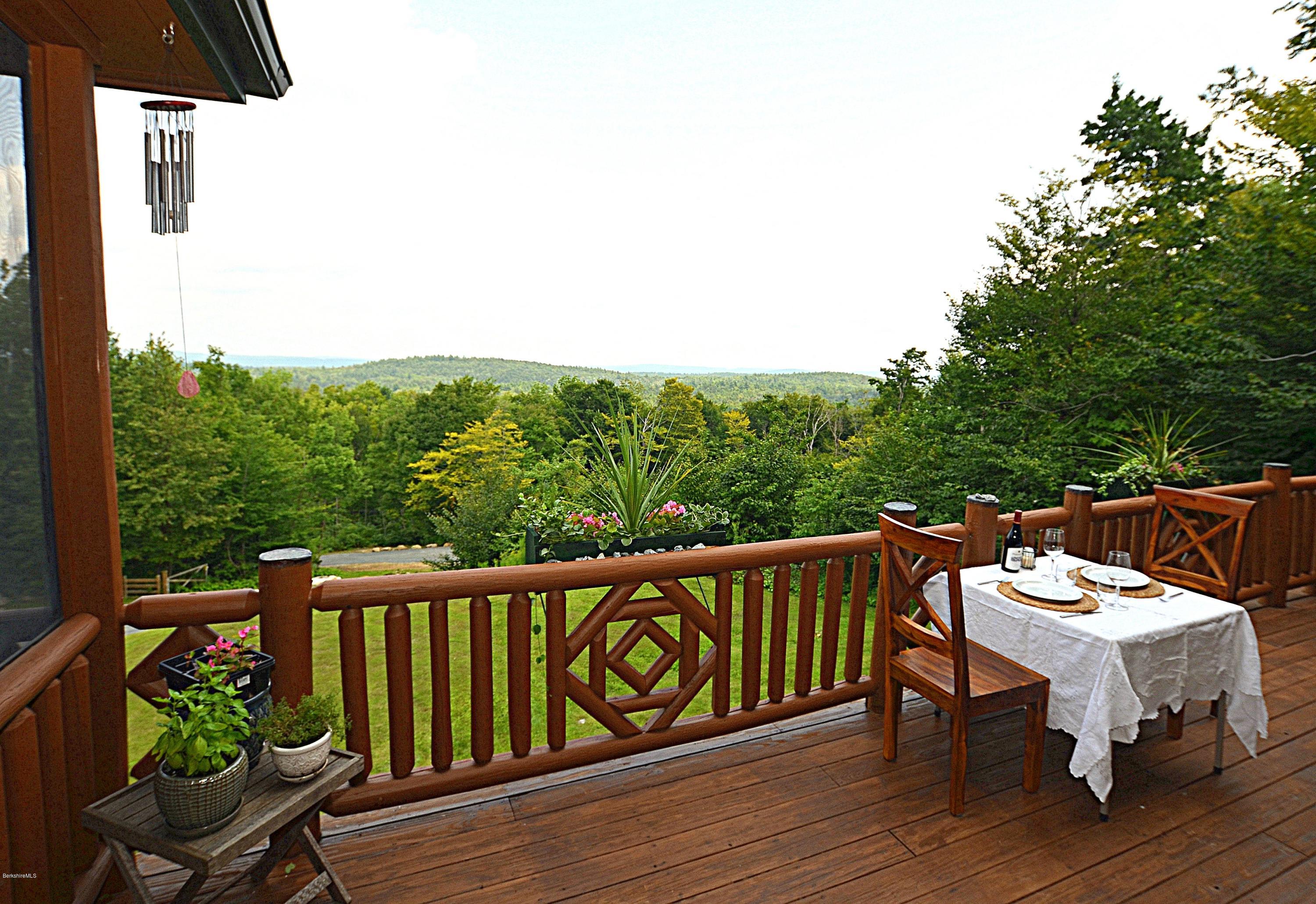 1297 Fred Snow Road Becket, MA 01223 - Photo 19 of 41 a balcony with wooden floor table and chairs